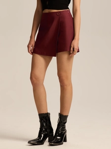 Detail of high-waist wine red wrap skort with side button and textured fabric finish