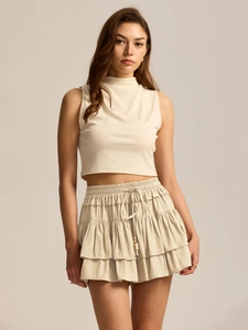 Detail of high waist skort with layered ruffle hem and beaded drawstring waist ties
