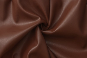 Macro shot of dark brown PU leather texture showing fine grain and soft material