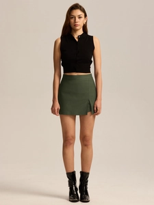 Full view of high waist split skort in dark green paired with black boots and crop top
