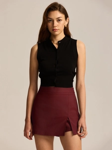 Detail of high waisted burgundy skort with side slit and black sleeveless knit crop top