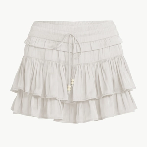 Detail of tiered ruffle mini skort with adjustable drawstring waist and cream fabric