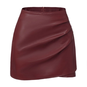 Detail shot of wine red PU leather skort featuring pleated drape and fine textured finish