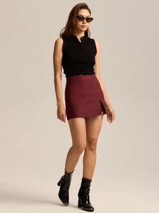 Detail shot of a side slit on a burgundy high-waisted A-line mini skirt for women