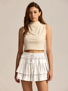 Detail view of white high-waisted tiered skort with drawstring and wooden beads