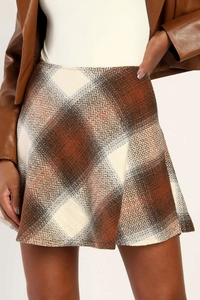Detailed macro view of the brown plaid tweed mini skirt texture and high waist tailoring