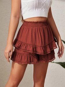 Detail of high waist elastic smocked skirt with tiered ruffles and delicate lace trim