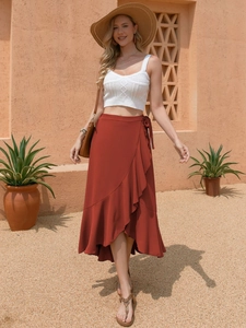 Detail of rust red wrap skirt with ruffled edges and tie waist in summer resort style
