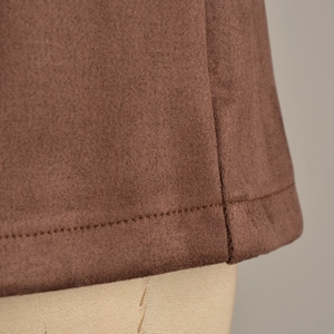 Detail of the brown faux suede skort showing double-stitched hem and soft fabric texture