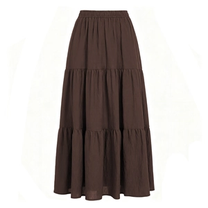 Dettaglio di gonna lunga marrone scuro a balze con vita elastica e texture in cotone naturale