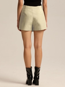 Rear view of high waisted irregular skort paired with black boots and sleeveless top