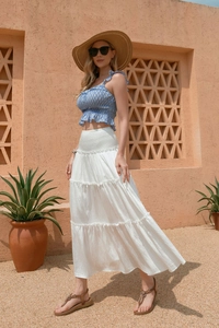 Détail d'une jupe longue blanche à volants en coton et lin avec taille haute smockée élastique