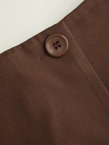 Detailed macro view of dark brown twill fabric with matching four-hole button