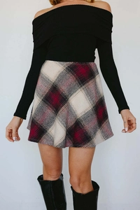 Detail of red and black plaid wool skirt with high-waist A-line flared silhouette