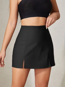Detail of high waisted black mini skirt featuring stylish double front slits and woven fabric