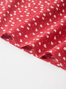 Détail du tissu en coton rouge à motif cœurs avec coutures de l'ourlet soignées