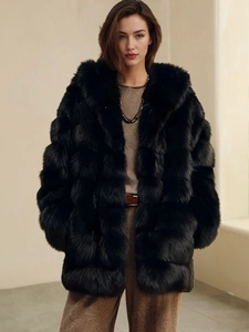 Close-up of fluffy black faux fox fur texture and hood detail on high-quality winter coat