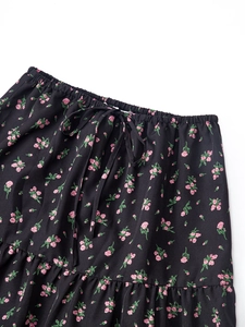 Détail du cordon de serrage élastique sur une jupe longue en coton noir à fleurs roses