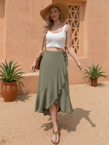 Deep green wrap skirt with ruffle hem and waist tie shown in a desert aesthetic setting