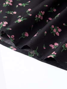 Détail du tissu en coton noir à motif floral rose pour jupe longue évasée à taille haute