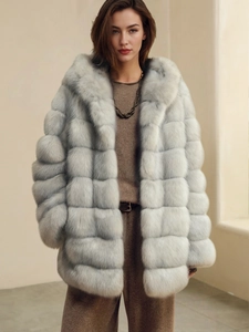 Close-up of fluffy faux fox fur coat featuring horizontal stitching and a hood