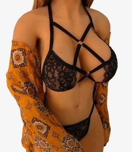 Detailansicht von schwarzem Spitzen-Dessous-Set mit Riemchen-Design unter bedrucktem Cardigan