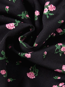 Gros plan détaillé de l'imprimé floral rose sur le tissu en coton noir d'une jupe longue