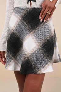 Macro detail of high-waist A-line plaid wool skirt featuring black and white herringbone texture