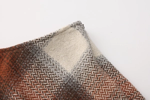Close-up of thick plaid wool skirt fabric showing herringbone texture and hidden zipper