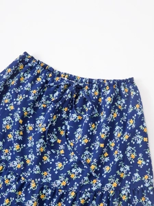 Détail de jupe à fleurs à taille haute avec ceinture élastique et nœud de serrage décor