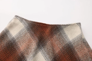 Close-up of high-waist wool blend skirt with brown herringbone plaid pattern detail