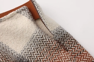 Detailed view of plaid wool skirt waist featuring brown elastic band and hidden zipper