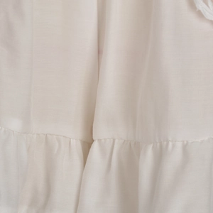 Detailed macro view of white tiered ruffle fabric with pleated lace texture and stitching