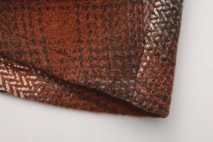 Detailed macro view of the rust red plaid woolen fabric texture on a high waist skirt