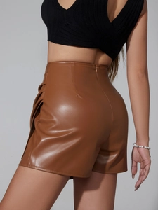 Detail shot of brown PU leather skort featuring side ruched pleats and hidden back zipper