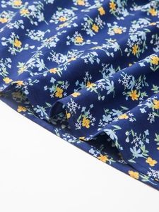 Vue macro détaillée du tissu en coton à fleurs bleu marine avec plis et textures