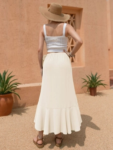 Detailed view of knitted tank top and ruffled long skirt for a boho vacation style