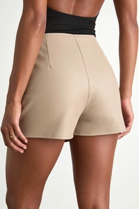 Back view of beige high-waisted PU leather skort showing slimming fit and modern seam design