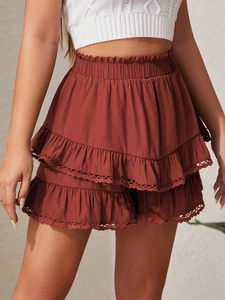 High-waisted rust red tiered skort with elastic waist and delicate lace trim details