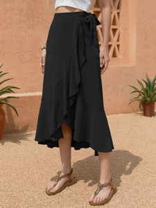 Detail showing the elegant black wrap skirt with ruffled edges and side tie closure