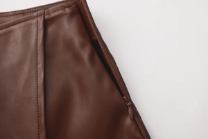 Detail of high waist brown PU skirt featuring a side hidden zipper and lychee texture