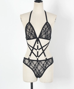 Détail d'un body en dentelle noire avec dos nu, anneaux en métal et découpes ajourées