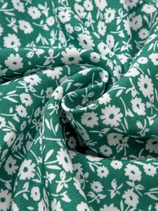 Gros plan d'un tissu en coton vert avec imprimé de marguerites et texture tissée