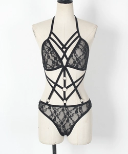 Dettaglio completo del set lingerie in pizzo nero con harness a cinghie e anelli metallici