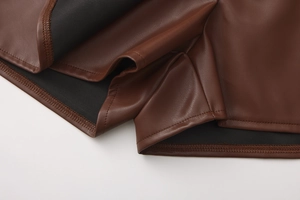 Close-up of brown PU leather texture and double-stitched hem on the high waist skirt