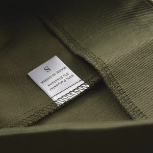 Detail view of clothing care label showing S size and 95% polyester fabric composition