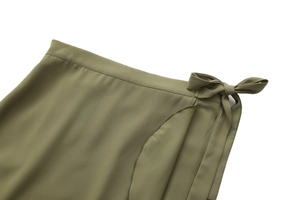 Detail of army green wrap skirt featuring a side bow tie and ruffled waist texture