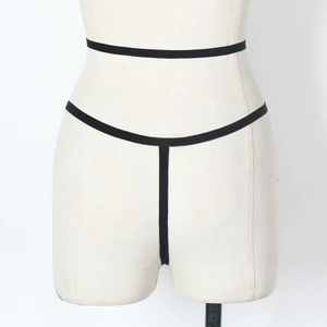 Detailed close-up of minimalist black lace thong with elastic straps on white mannequin