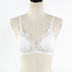 Détail de dentelle florale blanche délicate sur une brassière sans armature à fines bretelles