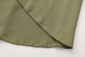 Detailed macro view of olive green ruffled hem with neat stitching on mid-length skirt